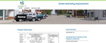 The screenshot showcases a website dedicated to public projects focused on street and utility improvement. It features a header image of parked cars along urban buildings, with sections labeled Project Overview, including a table, and Contact, offering a link for project updates.