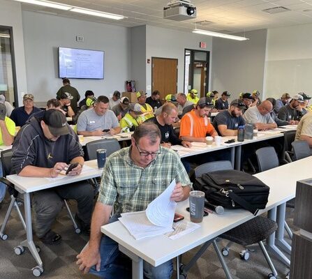 A group of people sitting at tables in a training session