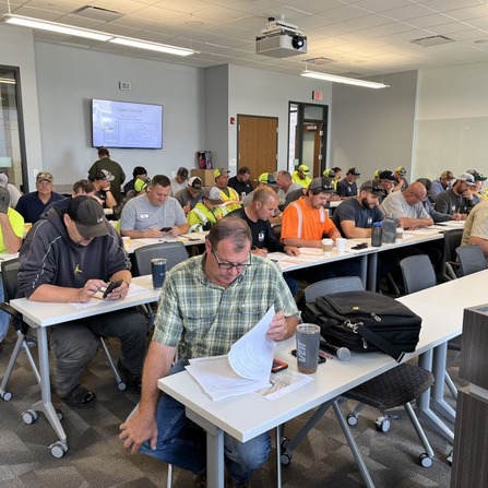 A group of people sitting at tables in a training session