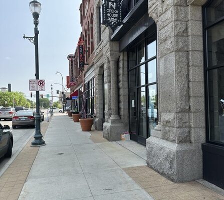 A sidewalk in front of a row of historic buildings