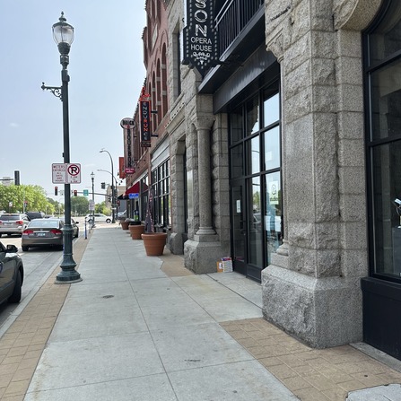 A sidewalk in front of a row of historic buildings