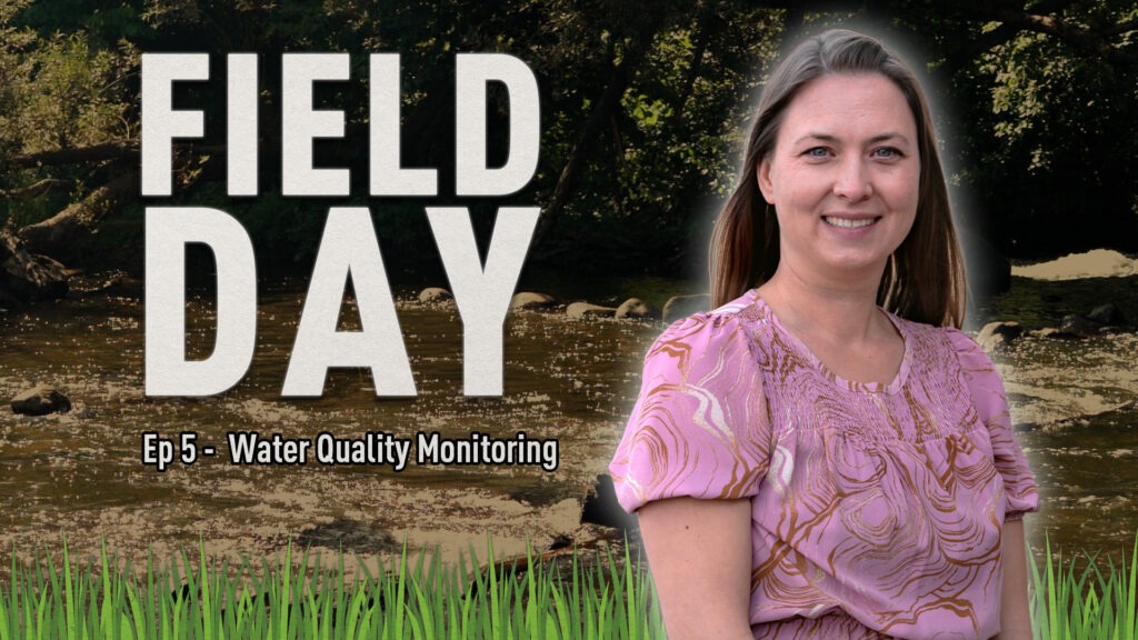 Graphic promoting “Field Day” Episode 5 on Water Quality Monitoring. The background shows a flowing stream surrounded by trees, with green grass at the bottom of the image. Large bold text reads “FIELD DAY,” and smaller text below says “Ep 5 - Water Quality Monitoring.” In the foreground, a person wearing a pink patterned blouse is positioned on the right side of the image.