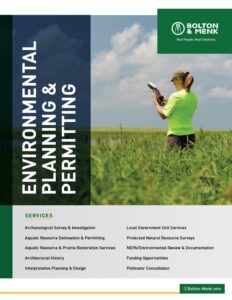 A woman in a bright green shirt and cap uses a tablet in a grassy field. The text reads “Environmental Planning & Permitting” and lists services such as surveys, restoration, and consultation, from Bolton & Menk.