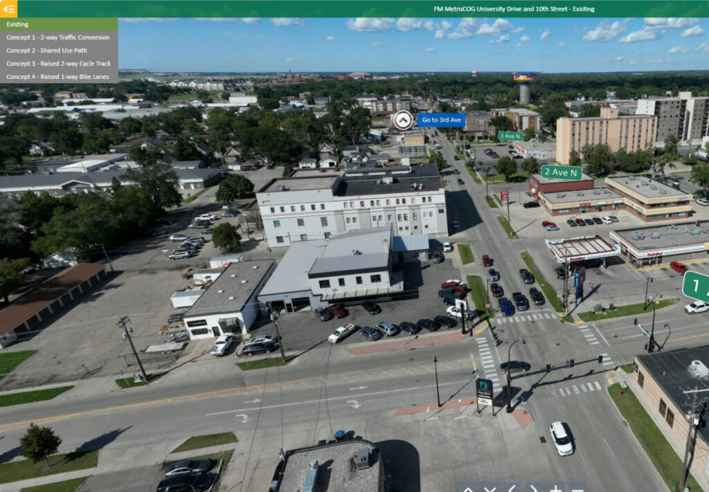 Aerial view of a busy city intersection with multi-lane roads, crosswalks, buildings, businesses, and parked cars. Direction signs and concept labels for traffic plans are overlaid on the image.